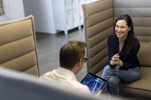 Smiling businesswoman having discussion with colleague in office - PESF04069