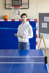 Young businessman standing with tablet PC near tennis table - PESF04112