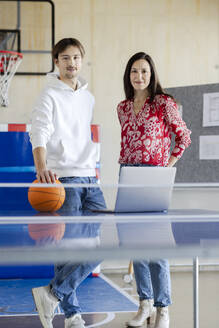 Smiling trainee standing with businesswoman in office - PESF04121