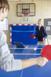 Business people playing tennis in modern office - PESF04133
