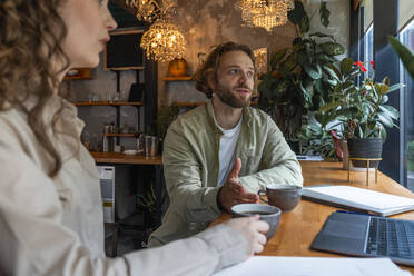 Geschäftsmann plant mit einem Kollegen einen Kaffee im Café - VPIF08726