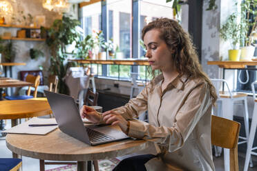 Geschäftsfrau arbeitet an einem Laptop in einem Café - VPIF08755