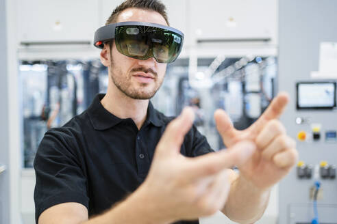 Techniker mit Augmented-Reality-Brille und Gesten in einer Fabrik - DIGF20586