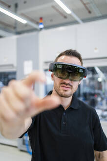 Techniker mit Augmented-Reality-Brille und Gesten in einer Fabrik - DIGF20589