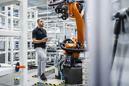 Techniker bei der Untersuchung eines Industrieroboters in einer Fabrik - DIGF20614