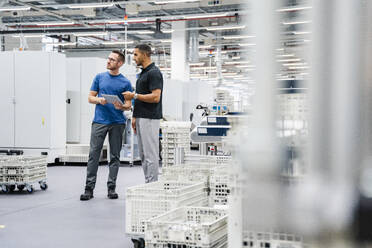 Two colleagues with digital tablet talking in a factory - DIGF20693