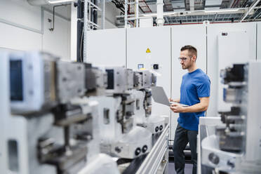 Techniker mit digitalem Tablet in einer Fabrikhalle - DIGF20719