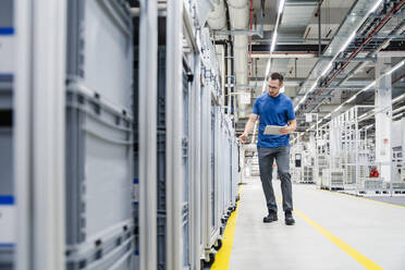 Techniker mit digitalem Tablet in einer Fabrikhalle - DIGF20726