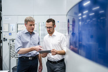 Zwei Geschäftsleute mit digitalem Tablet bei einer Besprechung in einer Fabrik - DIGF20737
