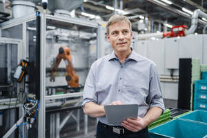 Geschäftsmann verwendet digitales Tablet in einer Fabrikhalle - DIGF20740