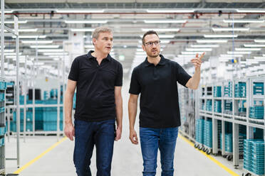 Two colleagues looking around in a factory - DIGF20802