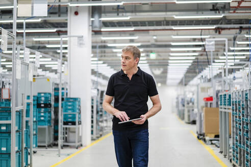 Techniker mit digitalem Tablet in einer Fabrikhalle - DIGF20807