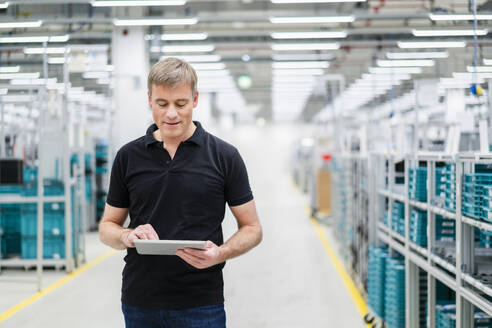 Techniker mit digitalem Tablet in einer Fabrikhalle - DIGF20809