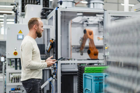 Technician using digital tablet on shop floor in a factory - DIGF20854