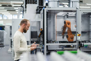 Technician using digital tablet on shop floor in a factory - DIGF20855