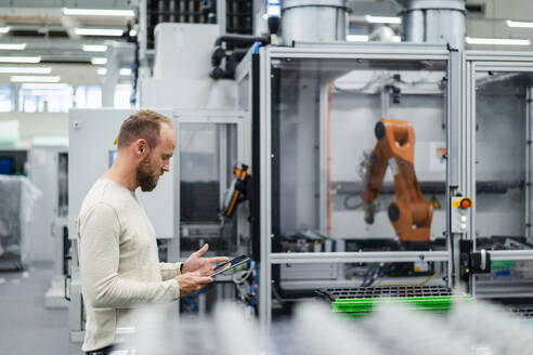 Techniker mit digitalem Tablet in einer Fabrikhalle - DIGF20855