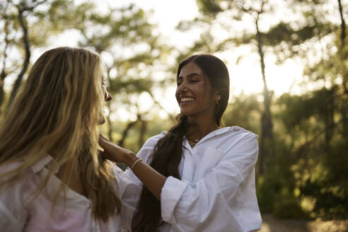 Glückliches Mädchen im Teenageralter schaut Mutter im Wald an - ANNF00508