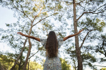 Teenager-Mädchen mit ausgestreckten Armen im Wald - ANNF00551