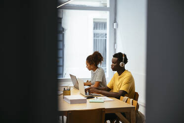 Junge Studenten beim Lernen und mit Laptop am Schreibtisch - EBSF03861