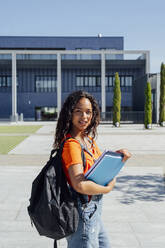 Junge Studentin mit Rucksack auf dem Campus - PGF01697