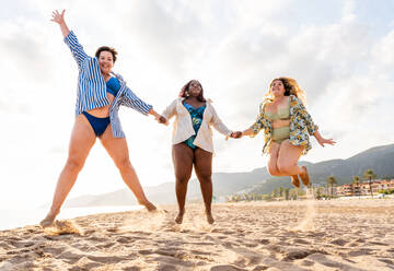 Group of beautiful plus size women with swimwear bonding and having fun at the beach - Group of curvy female friends enjoying summertime at the sea, concepts about body acceptance, body positive and self confidence - DMDF06974