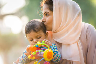Nahöstliche Familie mit traditioneller Kleidung hat Spaß im Freien - Moderne islamische Mutter und Sohn in Dubai - DMDF06976
