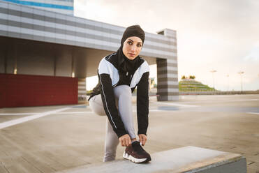 Woman with Muslim Sport Wear Stretching and Training at the