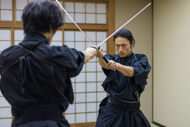 Japanischer Kampfsportler beim Kendo-Training in einem Dojo - Samaurai beim Üben in einer Turnhalle - DMDF07007