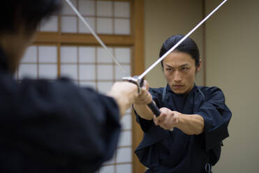 Japanischer Kampfsportler beim Kendo-Training in einem Dojo - Samaurai beim Üben in einer Turnhalle - DMDF07009