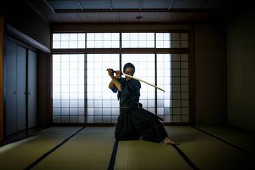Japanischer Kampfsportler beim Kendo-Training in einem Dojo - Samaurai beim Üben in einer Turnhalle - DMDF07017