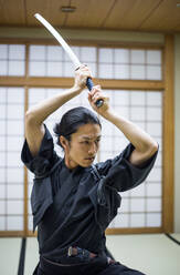 Japanischer Kampfsportler beim Kendo-Training in einem Dojo - Samaurai beim Üben in einer Turnhalle - DMDF07018