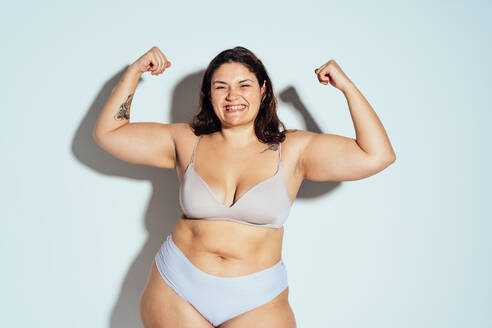 Plus size woman posing in studio in lingerie. Model on white background. Hard light studio shot - DMDF07036