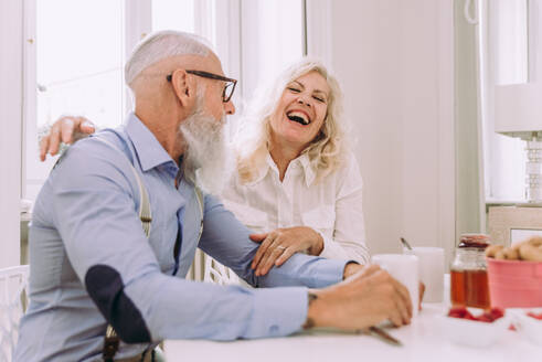 Glückliches älteres Ehepaar beim Frühstück zu Hause - Ehepaar in den 60er Jahren in ihrer Wohnung, Konzepte über Senorität und Beziehung - DMDF07052