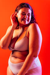Plus size Frau posiert im Studio in Dessous. Modell auf farbigem Hintergrund. Hartes Licht Studio Schuss - DMDF07067