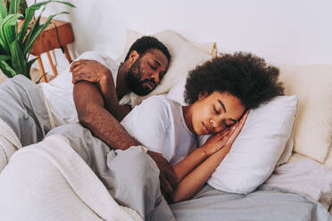 Afro american couple in bed - Real beautiful and cheerful pair of lovers at home - DMDF07123