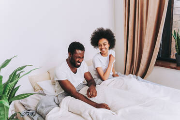 Afro american couple in bed - Real beautiful and cheerful pair of lovers at home - DMDF07124