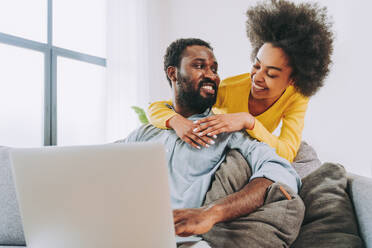 Schönes afro-amerikanisches Paar bei der Arbeit am Computer-Laptop-Gerät - Modernes Paar beim Online-Shopping - DMDF07139