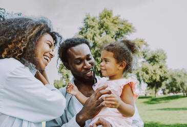 Schöne glückliche afrikanische amerikanische Familie, die sich im Park trifft - Schwarze Familie hat Spaß im Freien - DMDF07165