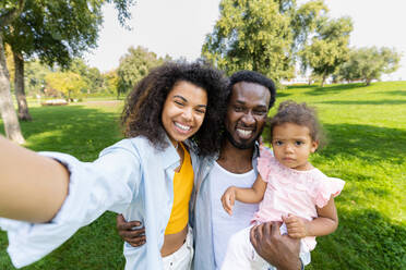 Schöne glückliche afrikanische amerikanische Familie, die sich im Park trifft - Schwarze Familie hat Spaß im Freien - DMDF07168