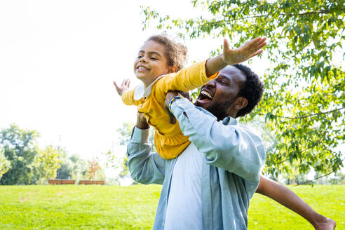 Schöne glückliche afroamerikanische Familie im Park - Schwarze Familie hat Spaß im Freien, Papa spielt mit seiner süßen Tochter - DMDF07216