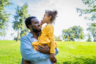 Schöne glückliche afroamerikanische Familie im Park - Schwarze Familie hat Spaß im Freien, Papa spielt mit seiner süßen Tochter - DMDF07217