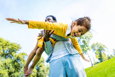 Schöne glückliche afroamerikanische Familie im Park - Schwarze Familie hat Spaß im Freien, Papa spielt mit seiner süßen Tochter - DMDF07218