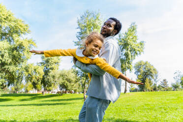 Schöne glückliche afroamerikanische Familie im Park - Schwarze Familie hat Spaß im Freien, Papa spielt mit seiner süßen Tochter - DMDF07219