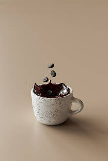 3D-Rendering von Kaffeebohnen, die in eine Tasse Kaffee fallen - GCAF00431