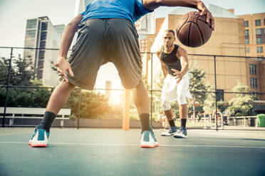 Zwei afroamerikanische Athleten spielen Basketball im Freien - Basketballer trainieren auf einem Platz in New York - DMDF07348