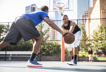 Two afroamerican athlethes playing basketball outdoors - Basketball athlete training on court in New York - DMDF07349