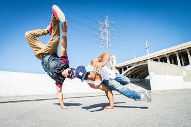 Zwei Bbys machen ein paar Stunts - Straßenkünstler und Breakdancer machen ein akrobatisches Selfie im Freien - DMDF07374