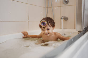 Glücklicher Junge beim Baden in der Badewanne - ANAF02213