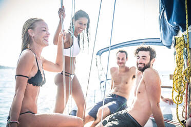 Multiethnische Gruppe von Freunden beim Segeln auf einem Boot - Sommerferien, junge Erwachsene haben Spaß - DMDF07400