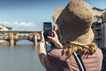 Tourist mit Hut beim Fotografieren der Ponte Vecchio über dem Arno - JSRF02649